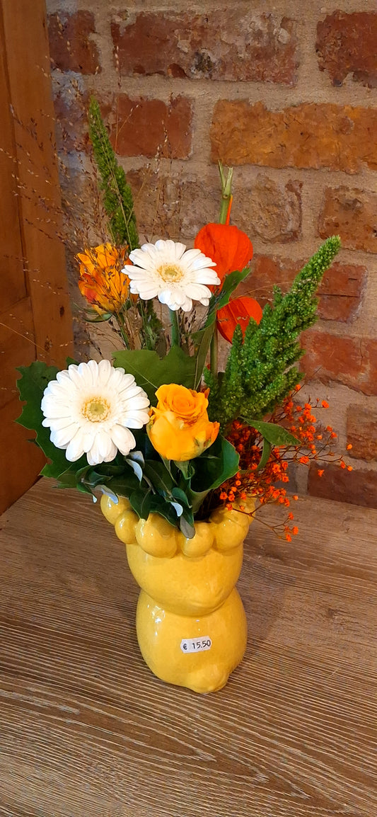 Vase of lemons with seasonal flowers